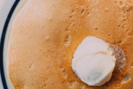 Fresh pancakes with butter on a breakfast plate